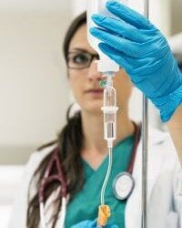 Young-woman-doctor-anesthesiologist-dressed-in-green-gown-puts-499699416_838x1256-200x300