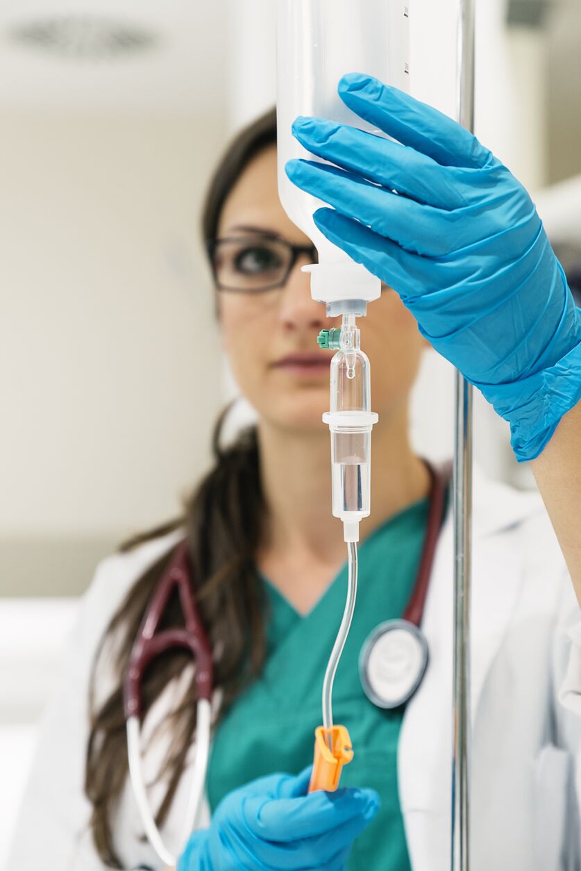 Young woman doctor anesthesiologist dressed in green gown, puts